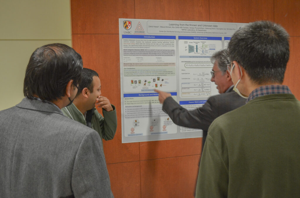 Students, Faculty and Staff discussing a research poster