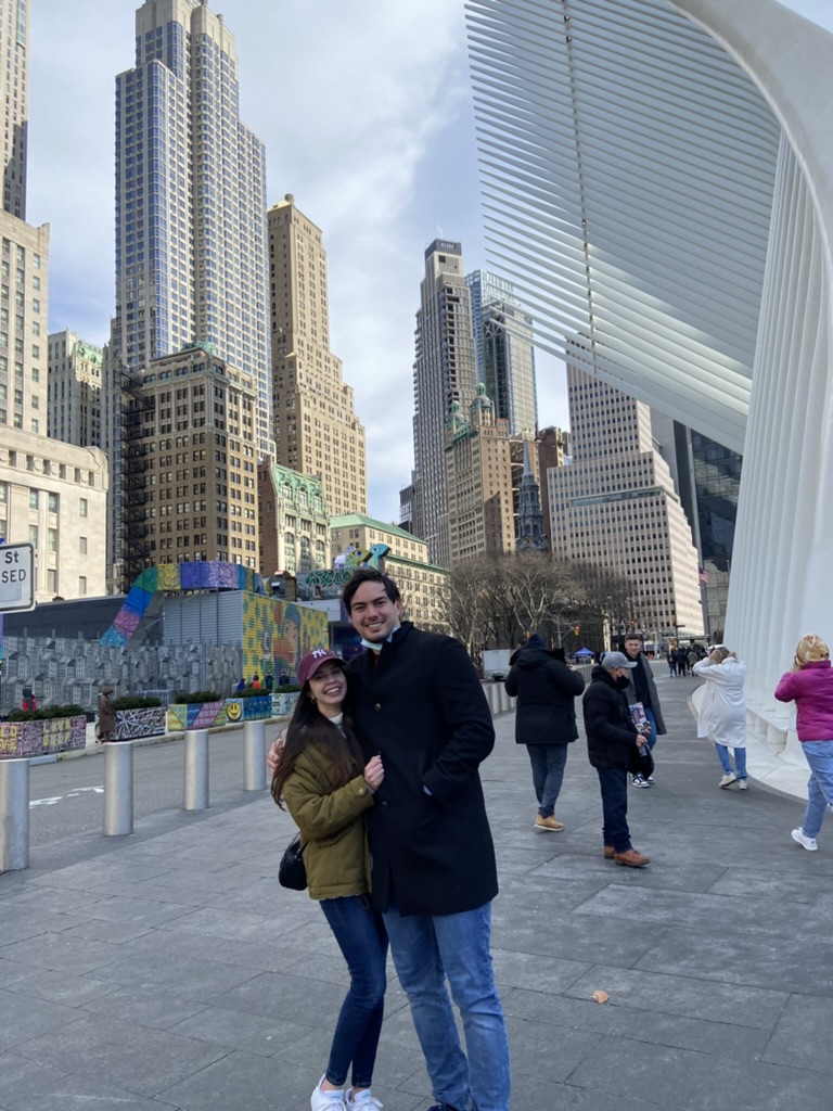 two people posing for a photo in a busy city