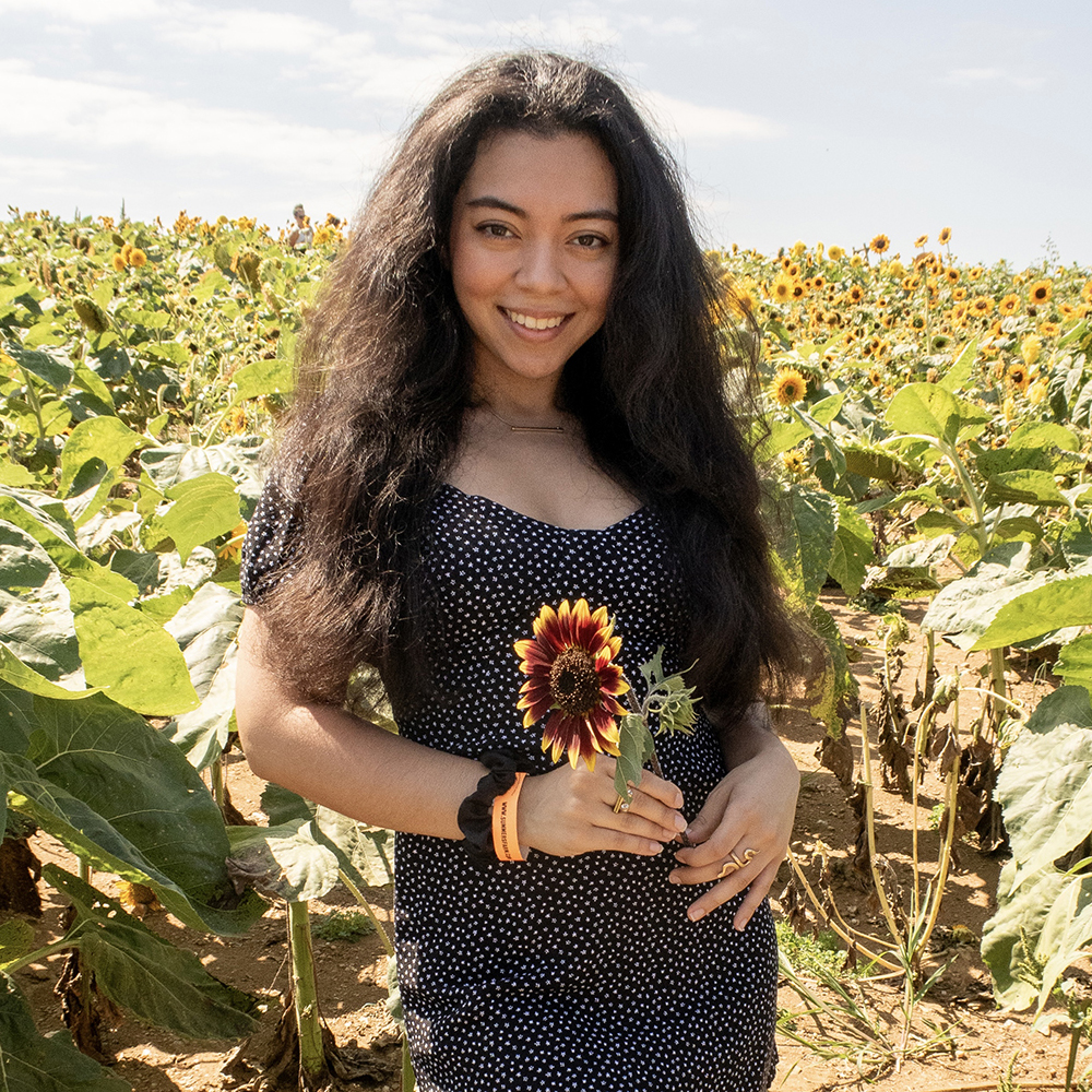 Photo of Jennifer Posada Granados in a sunflower field
