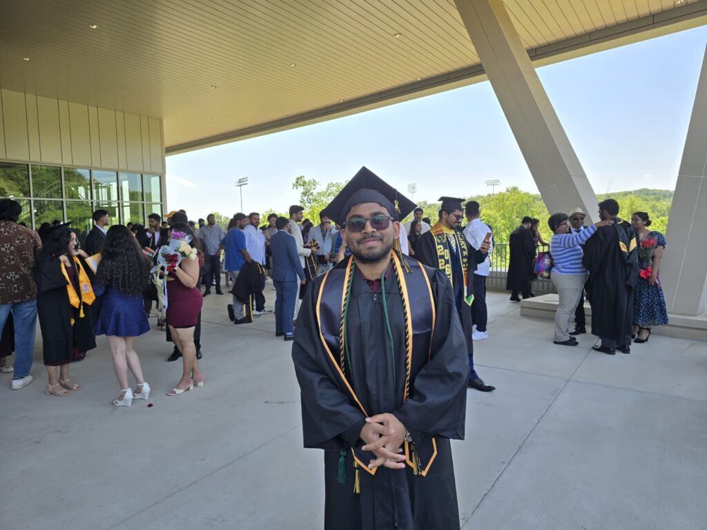 Shashank Puppala standing outside of the arena on campus after graduation
