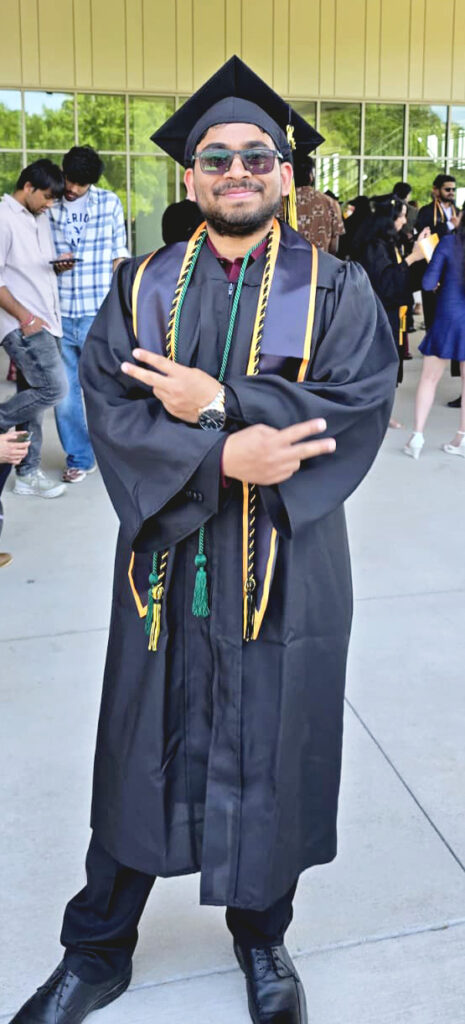 Shashank Puppala standing outside of the arena on campus after graduation